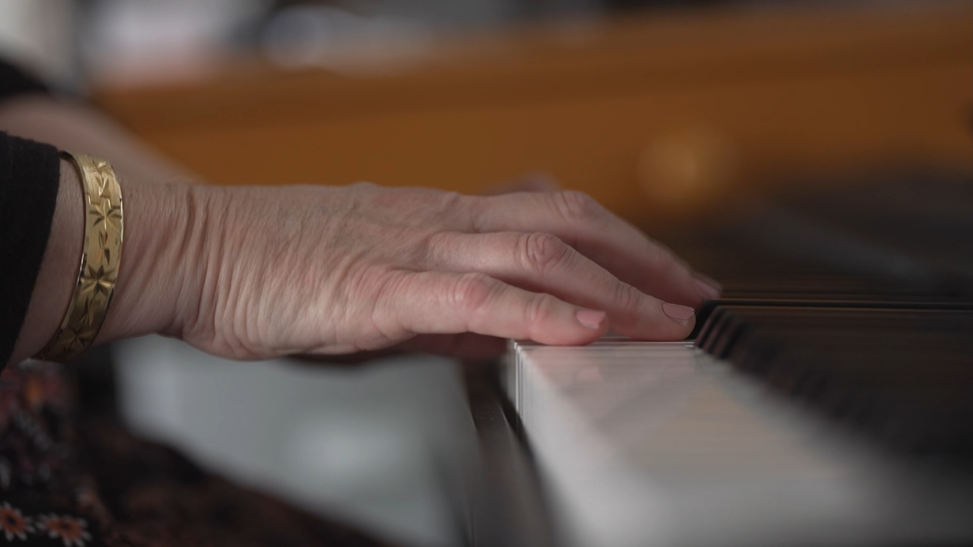 Hands play the keys of a piano