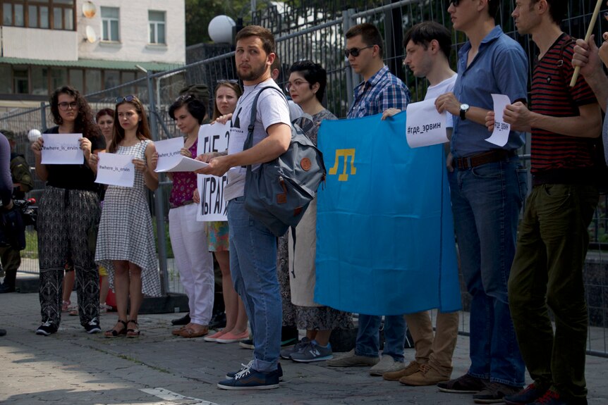 Protestors hold signs at a demonstration in front of the Russian embassy in Kiev.