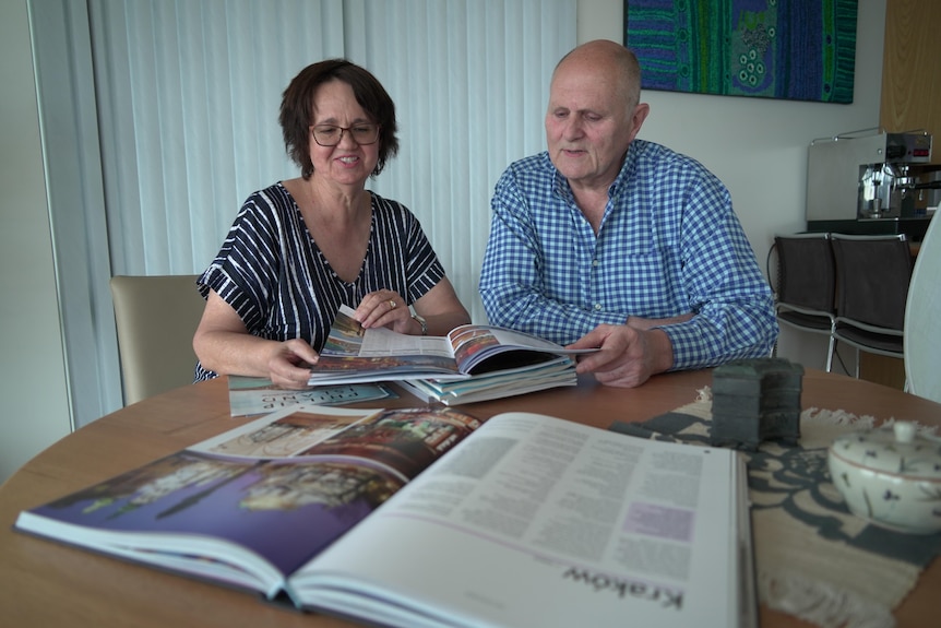 A woman and a man look at books on a table