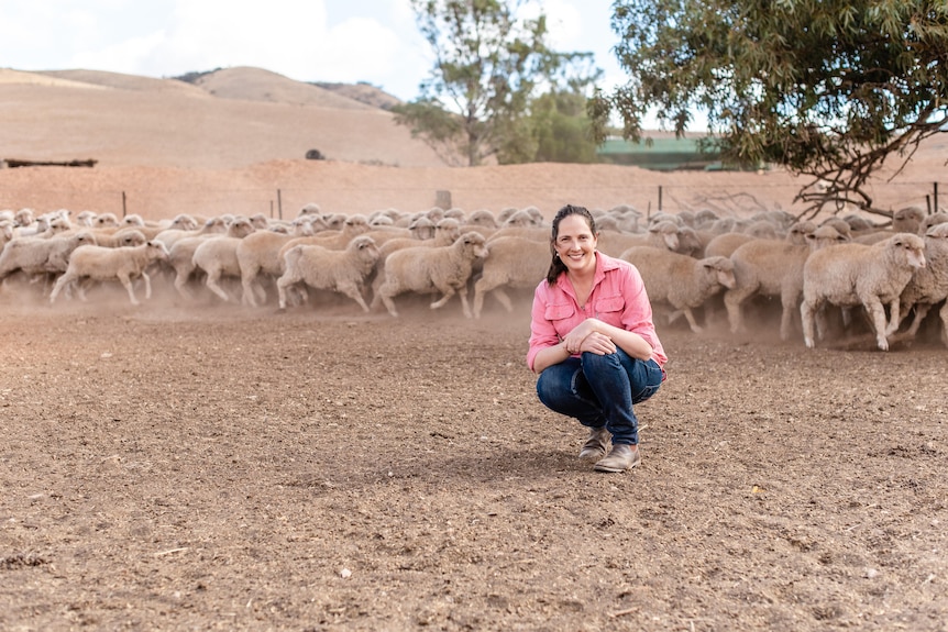 Farmer Stephanie Schmidt in a paddock with some sheep. 