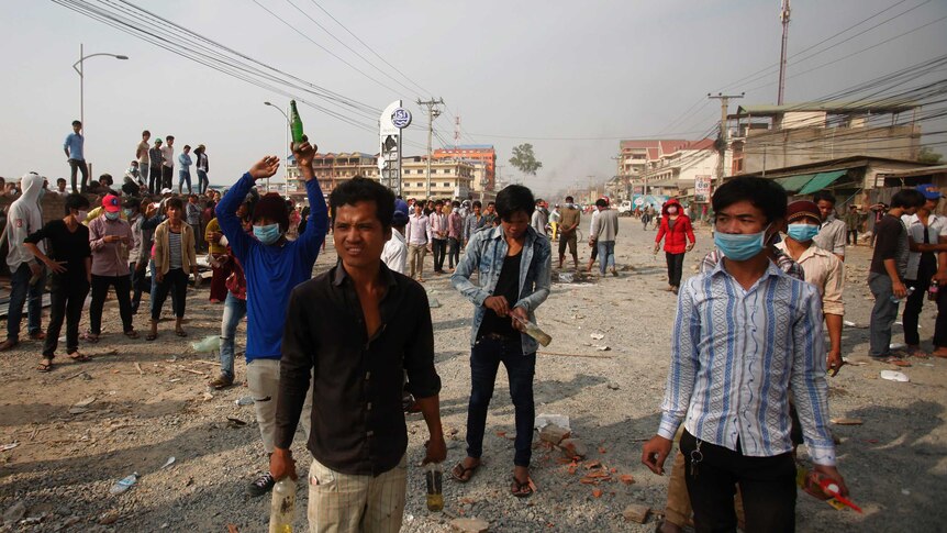 Garment workers hold petrol bombs after clashes in Cambodia