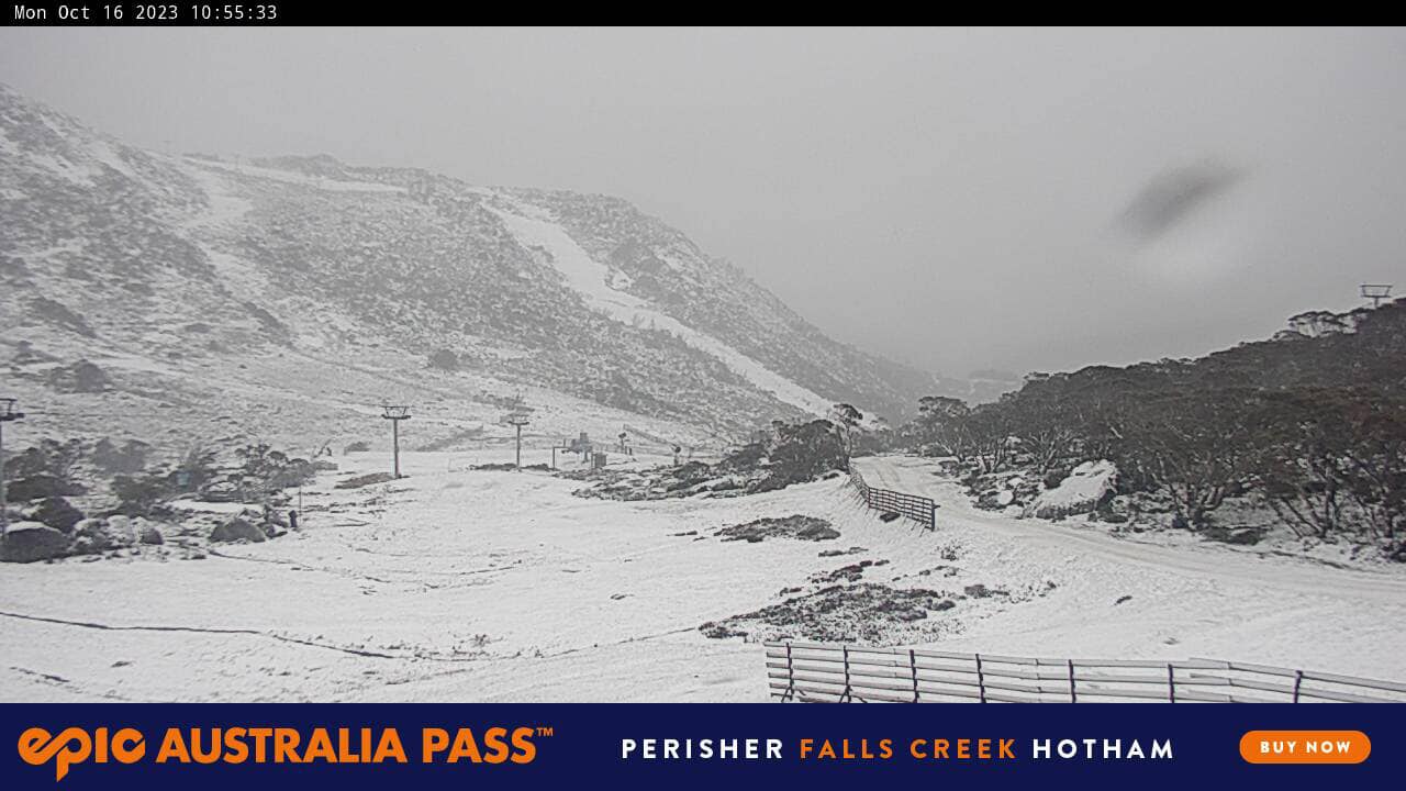 A valley and mountains at Perisher covered in white snow with misty clouds in the background