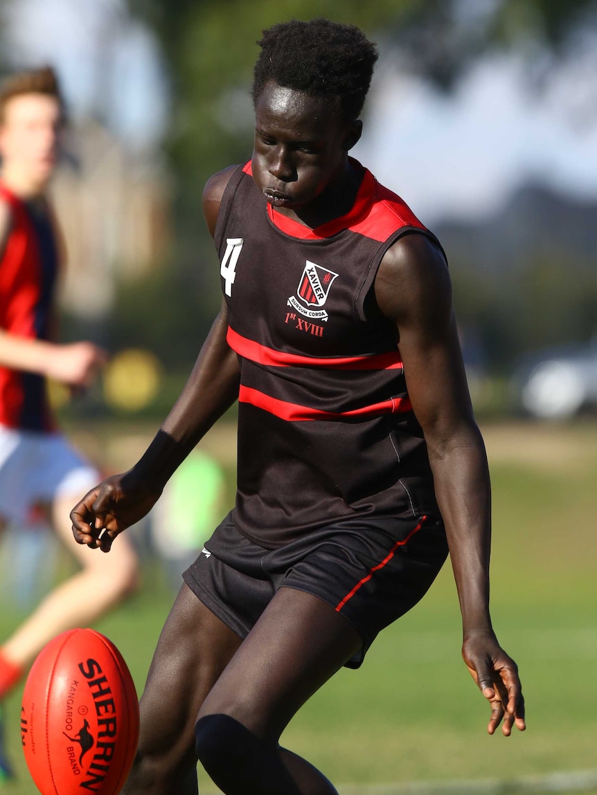 CJ playing football for Xavier College.