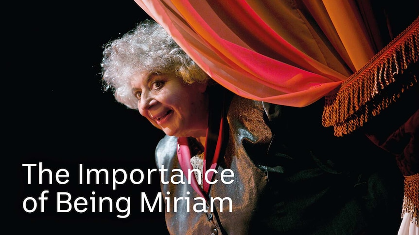 Miriam Margolyes peeking from a curtain