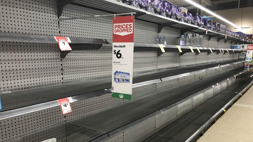 A row of empty supermarket shelves.