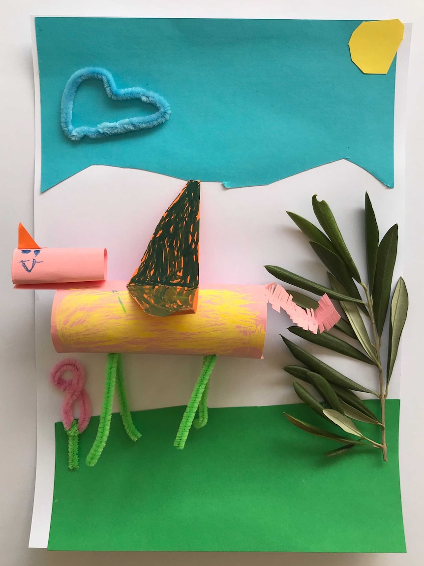 Toilet rolls, paper and an olive branch arranged as a unicorn and tree in a mixed-media artwork.