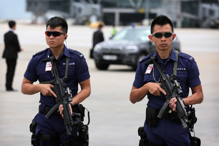 Armed Hong Kong police stand guard before the arrival of Zhang Dejiang.