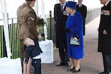 Michelle Lun holds on to her son Alfie, 2, as they greet the queen