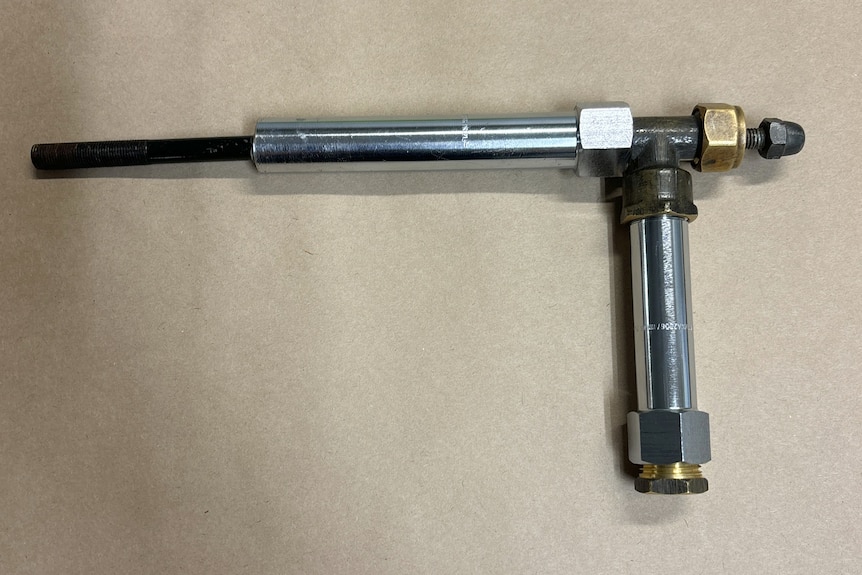 A gun made from pipe parts and nuts and bolts.