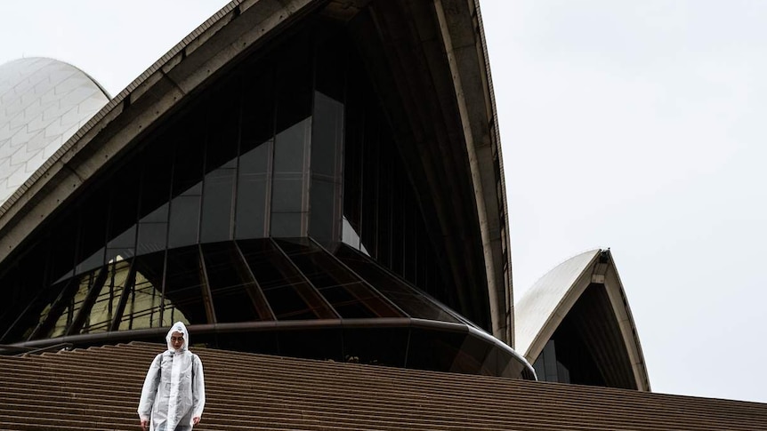 A man walks down the steps of the Sydney Opera House