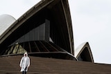 A man walks down the steps of the Sydney Opera House