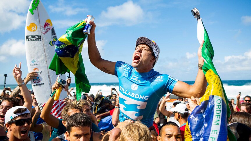 Adriano de Souza is carried from the surf on shoulders of supporters after winning the world surfing title.