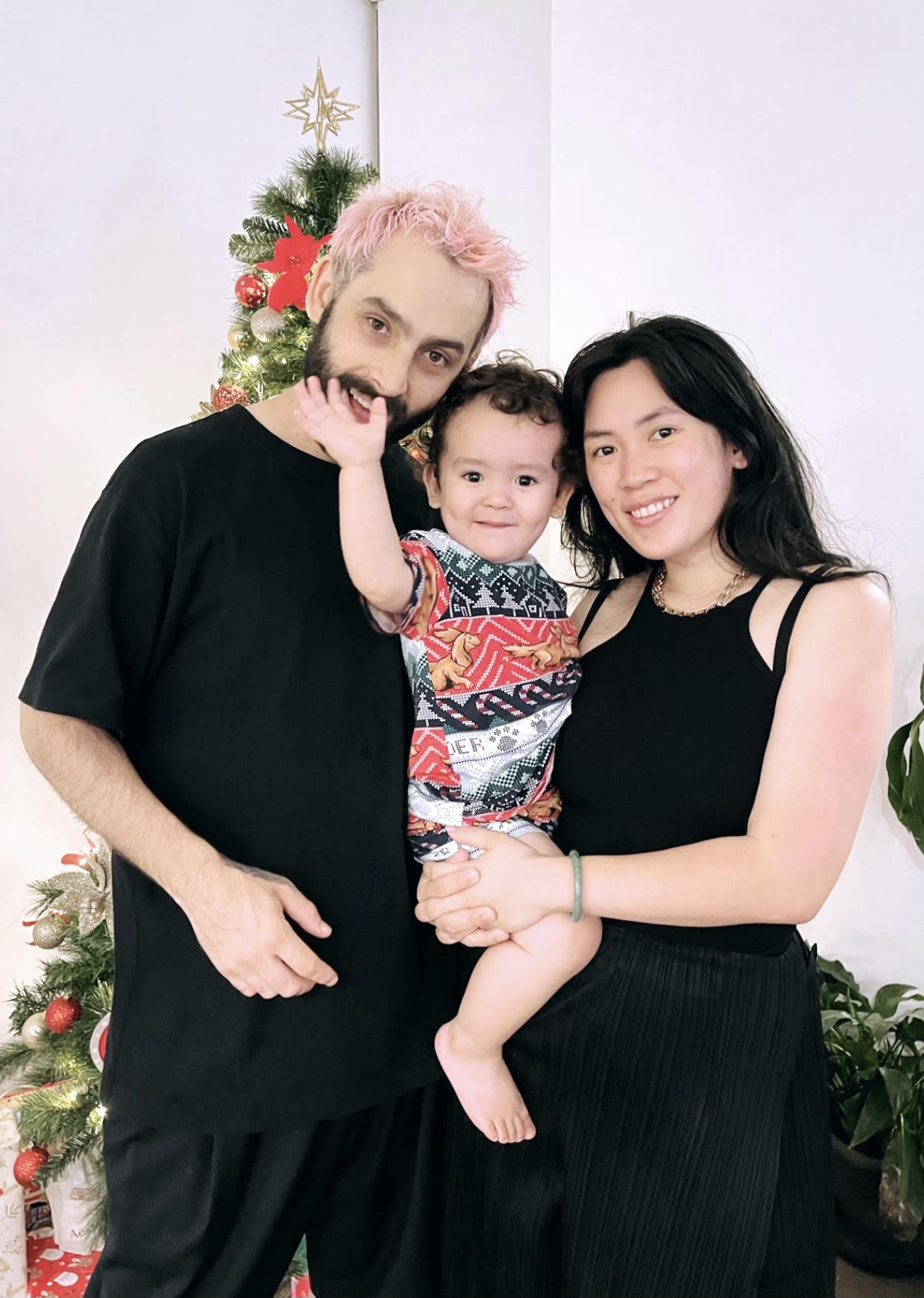 A man and a woman stand together holding a young child for a story about only children and the benefits for child and parent.