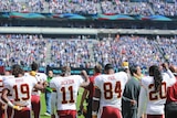 Washington Redskins players raise their fists during national anthem in NFL game against New York.