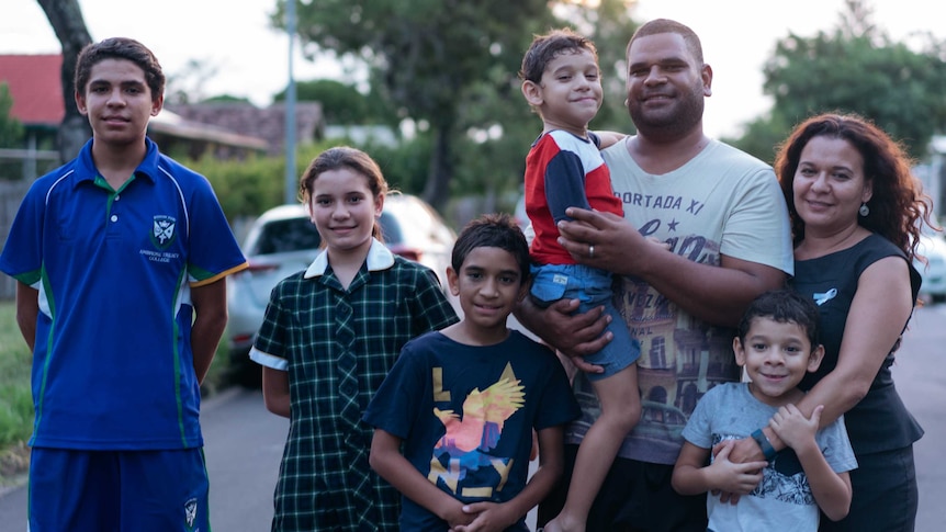 Chelsea Bond stands with her husband Matt and their five children on the street outside their house.