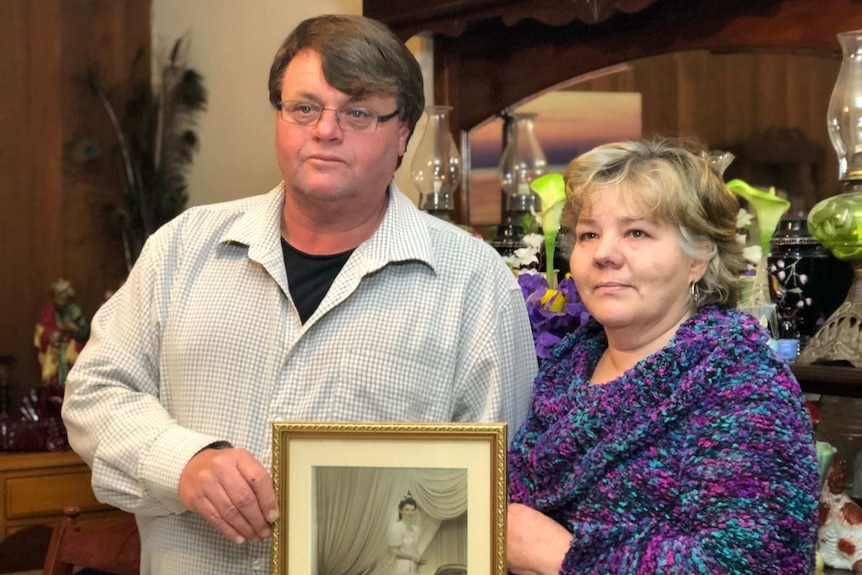 A couple holds a framed image black and white image