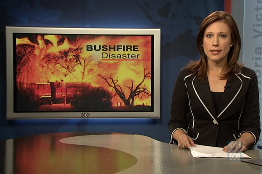 Tamara Oudyn at news desk with TV screen with photo of flames and words bushfire disaster on screen.