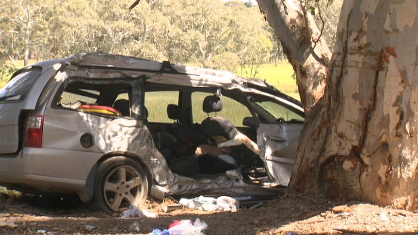 A car with major damage after hitting a tree.