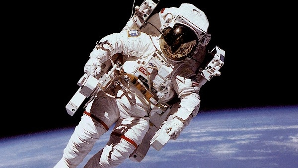 Astronaut floating in space above the Earth