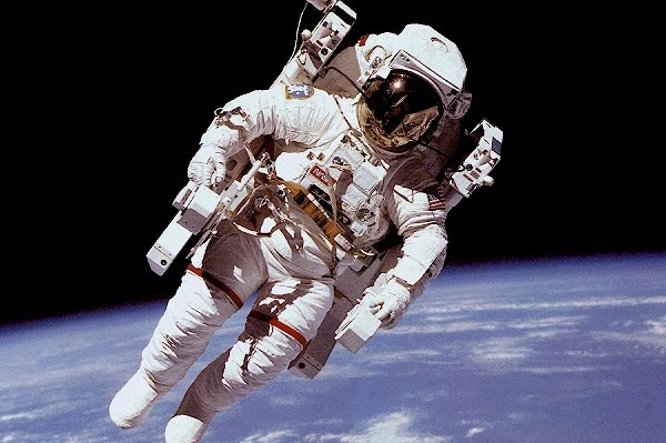 Astronaut floating in space above the Earth