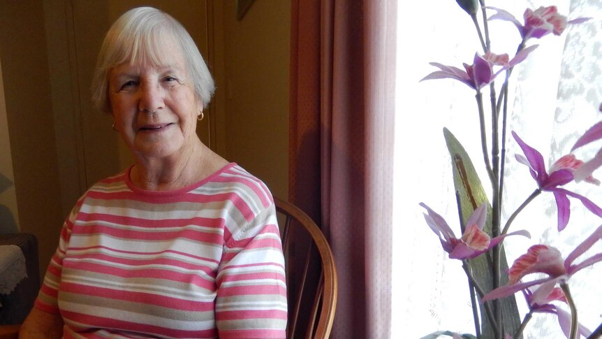 Margaret Evans sits next to flowers.