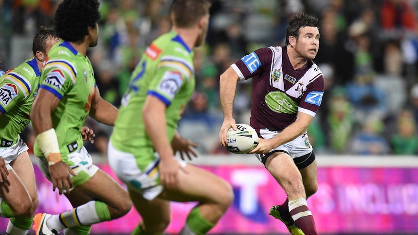 Manly's Jamie Lyon (R) looks to pass the ball against Canberra at Canberra Stadium in June 2016.