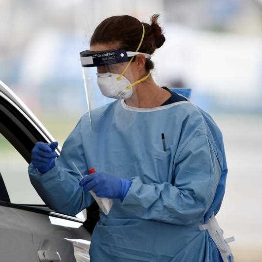A nurse testing someone through a car window in Bondi.