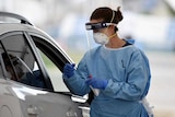 A nurse testing someone through a car window.