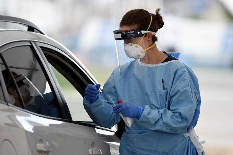 A nurse testing someone through a car window in Bondi.