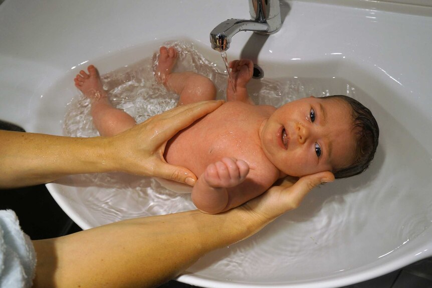 Baby Cyan being bathed