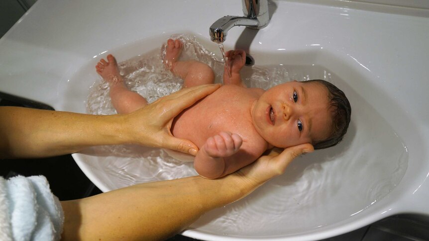Baby Cyan being bathed