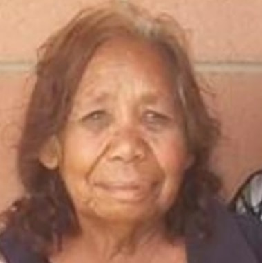 An older Aboriginal woman smiles at the camera.