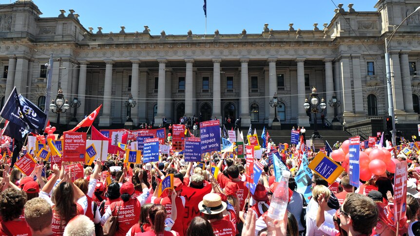 Nurses and supporting trade unionists rally outside Parliament House in Melbourne.