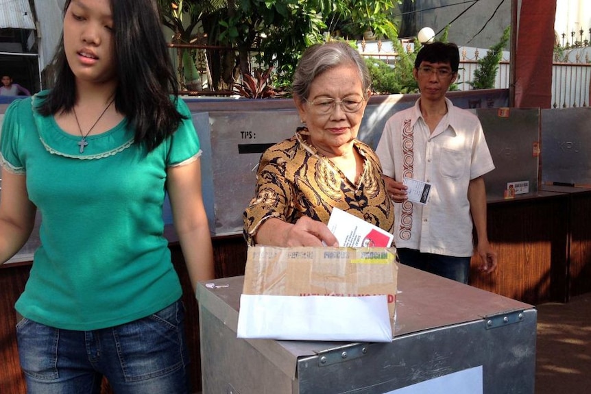 A woman casts her vote at a voting booth in Jakarta.