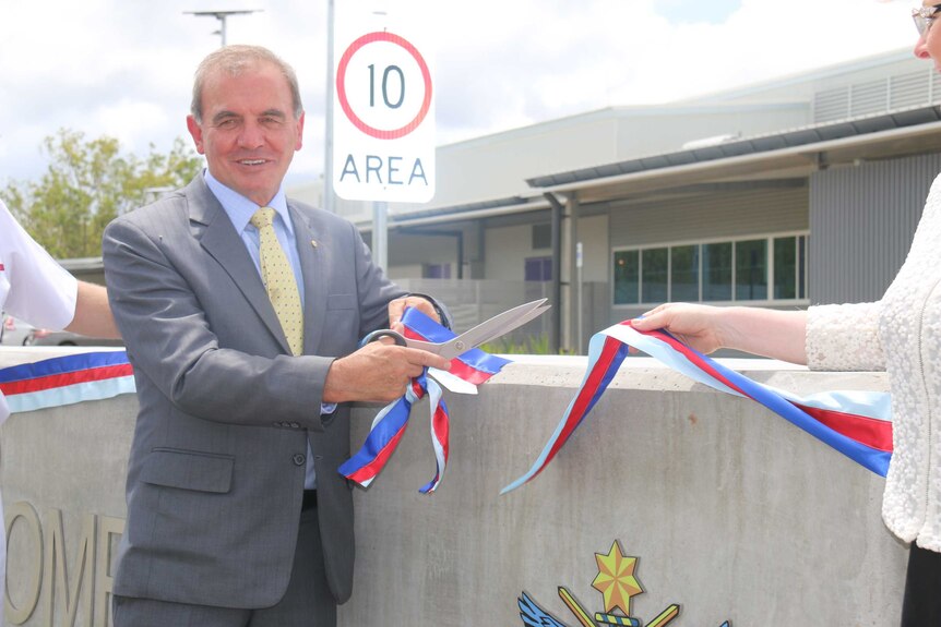 Retired Major General Peter Haddad cuts the ribbon at the official opening of new storage facility in Darwin