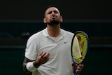 Nick Kyrgios grimaces with his eyes closed after a point during his first-round Wimbledon match.