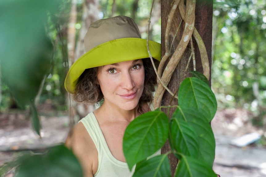 A woman's face close up with a green vine