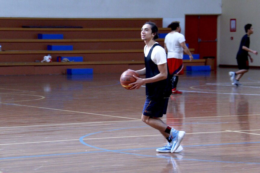 Indigenous teen Jarrod Hampton playing basketball.