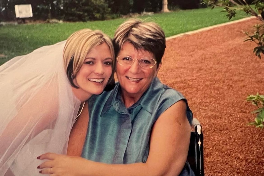 Lady in wedding dress with Carol in wheelchair