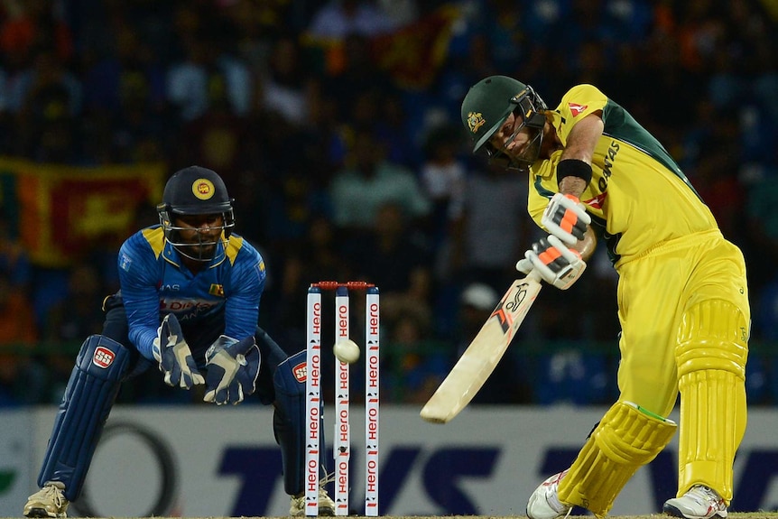 Australia's Glenn Maxwell hits another boundary as Sri Lankan keeper Kusal Perera looks on in T20