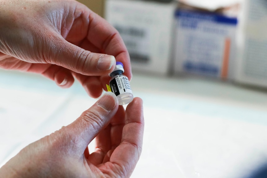 Nurse holds a vial of Pfizer COVID-19 vaccine.