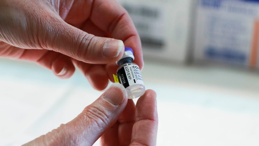 Nurse holds a vial of Pfizer COVID-19 vaccine.