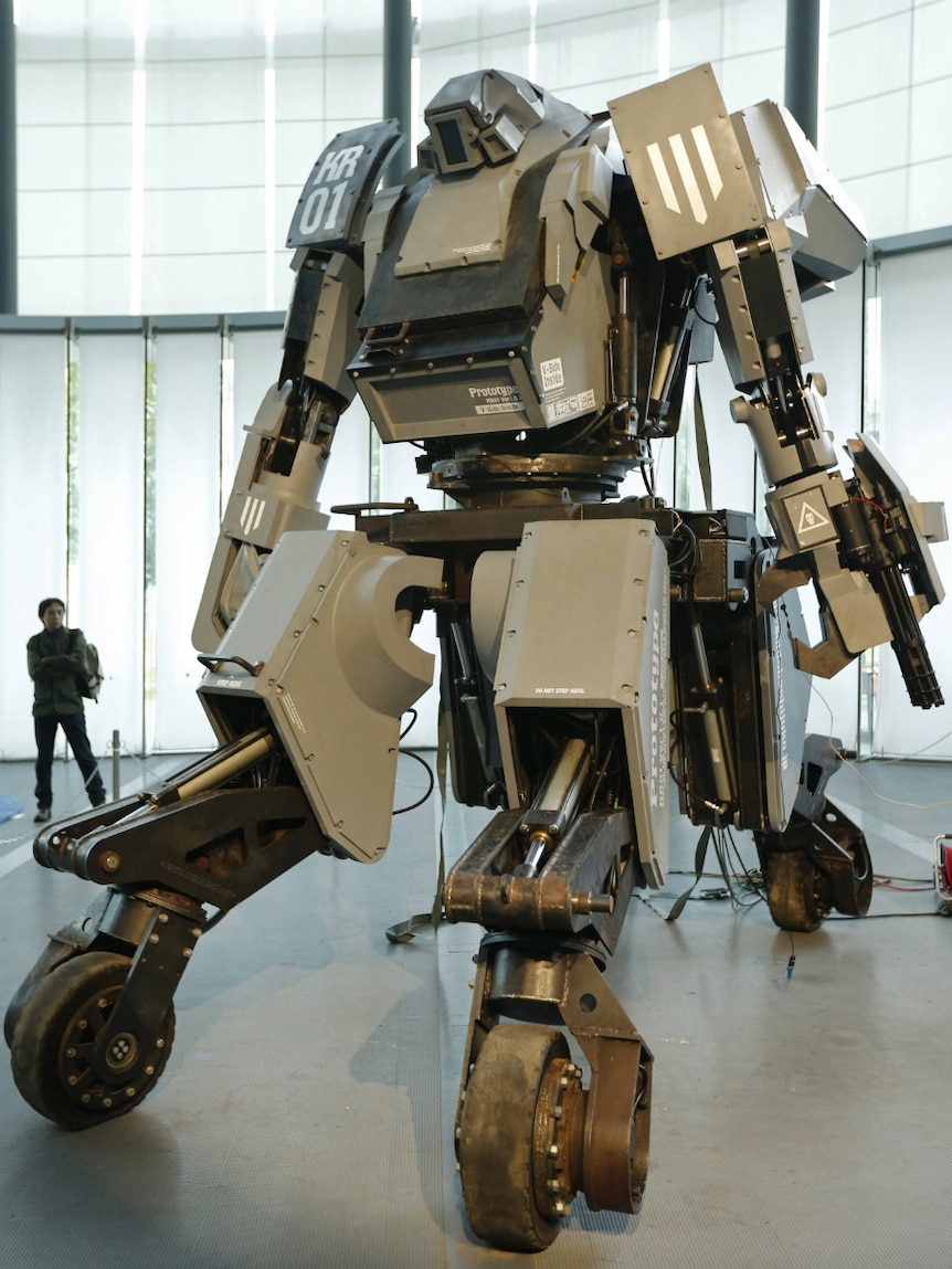 A man looks at a giant "Kuratas" robot at an exhibition in Tokyo.