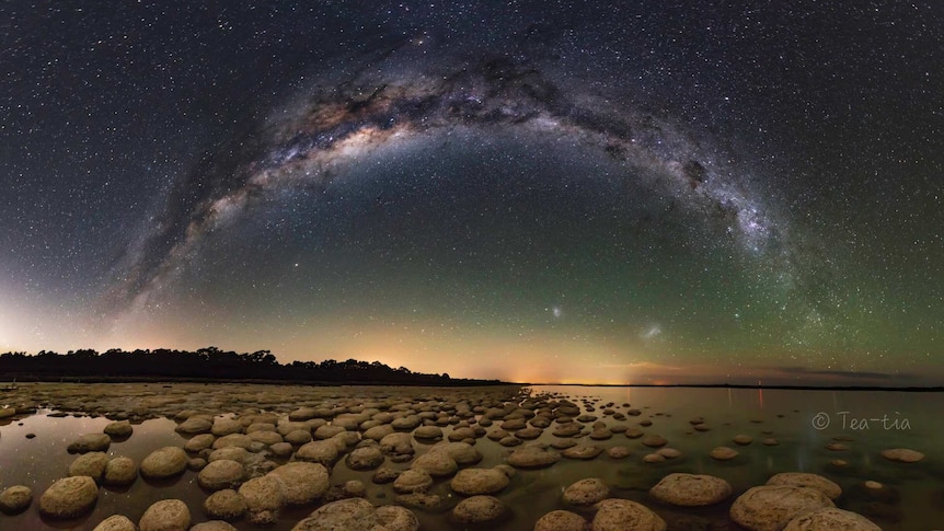 A starry sky is reflected in the shallows of rockpools along the WA coastline.