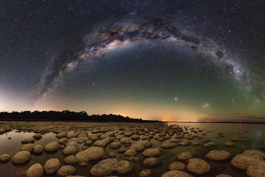 A starry sky is reflected in the shallows of rockpools along the WA coastline.