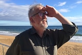 Man on a beach looking up at the sky