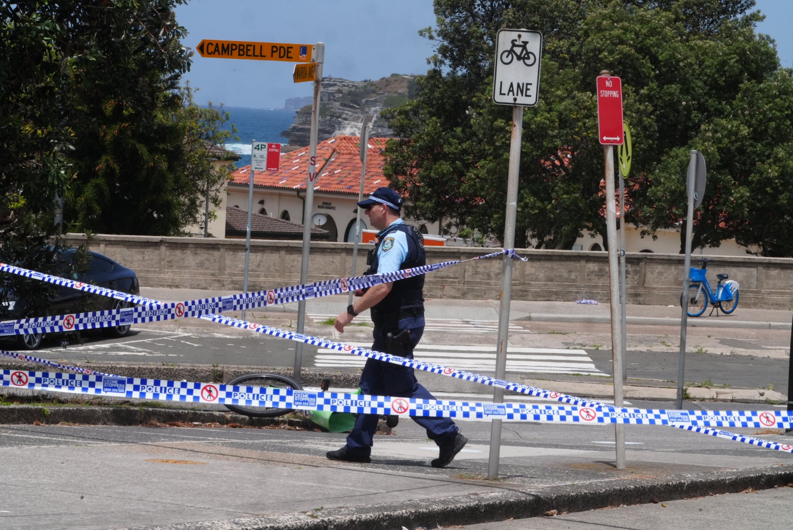 Un oficial de policía estaba detrás de una cinta policial en Campbell Parade.