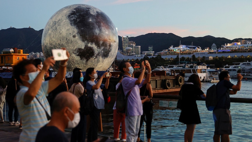 People take pictures in front of a giant moon-shaped balloon ahead of Mid-Autumn Festival, in Hong Kong, China. 