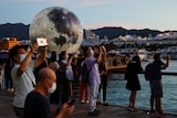 People take pictures in front of a giant moon-shaped balloon ahead of Mid-Autumn Festival, in Hong Kong, China. 
