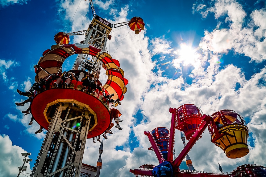 Colourful fairground rides on a sunny day.